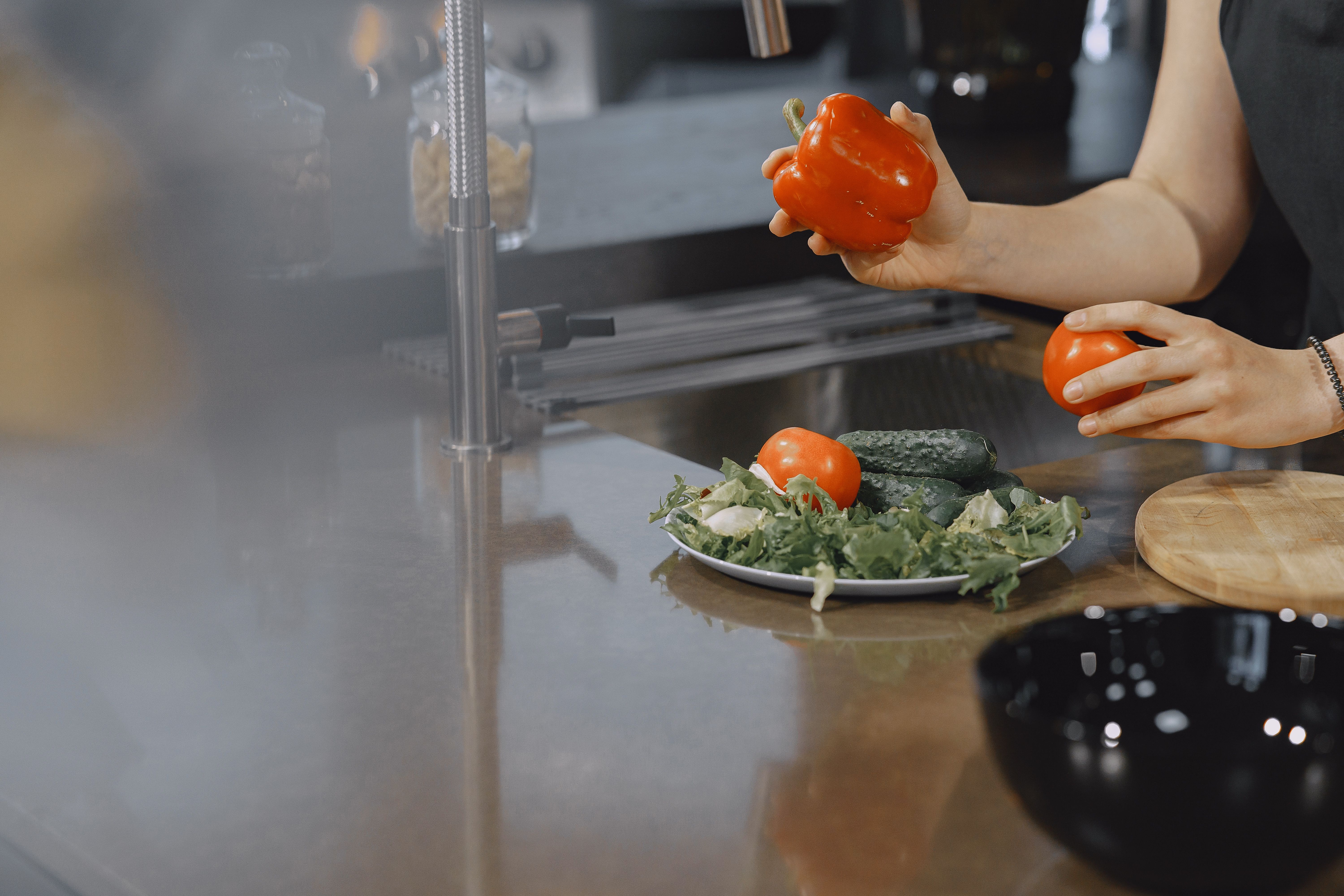 Freshly sliced tomatoes and pickles on a prep table