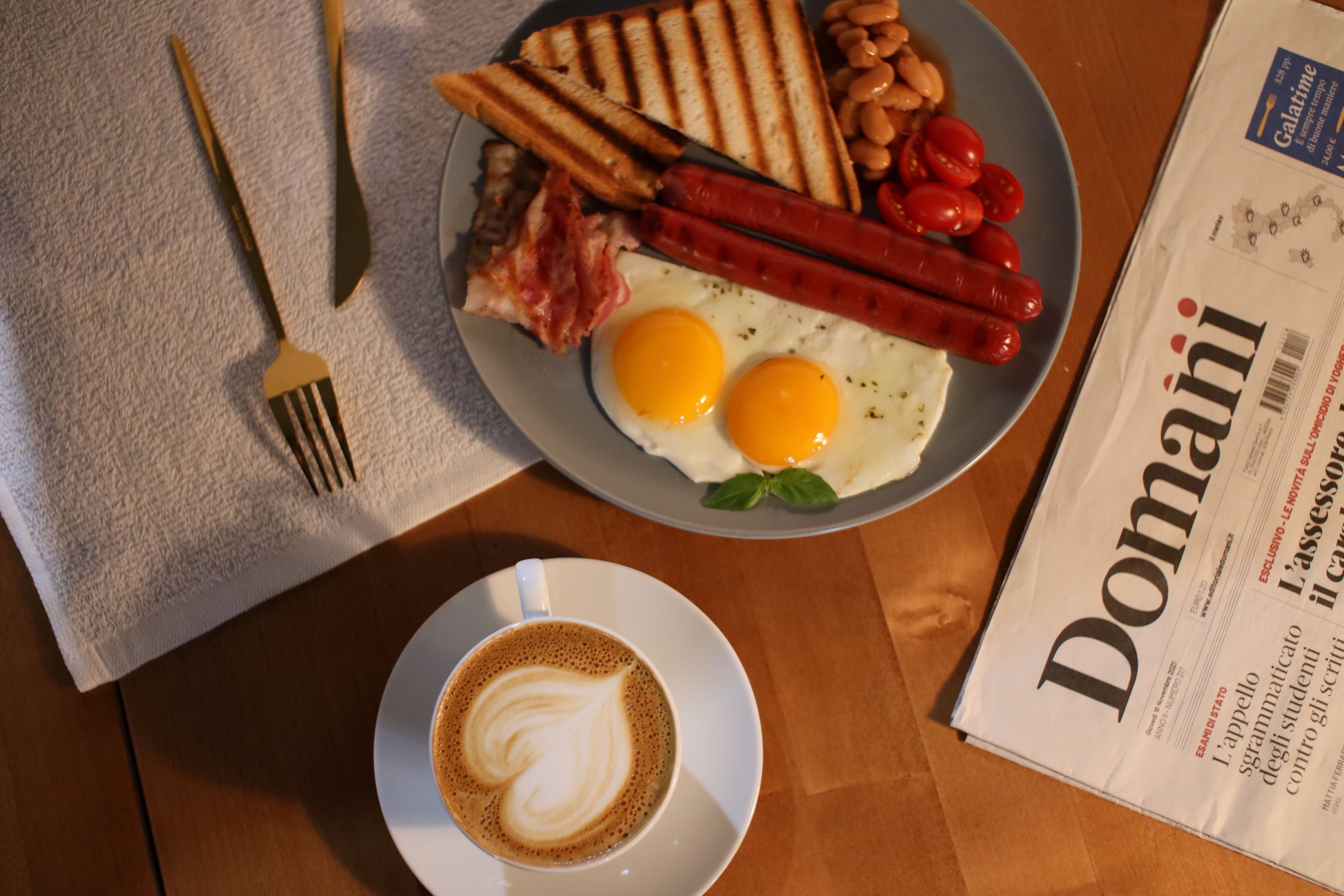Open newspaper and a cup of black coffee on a table
