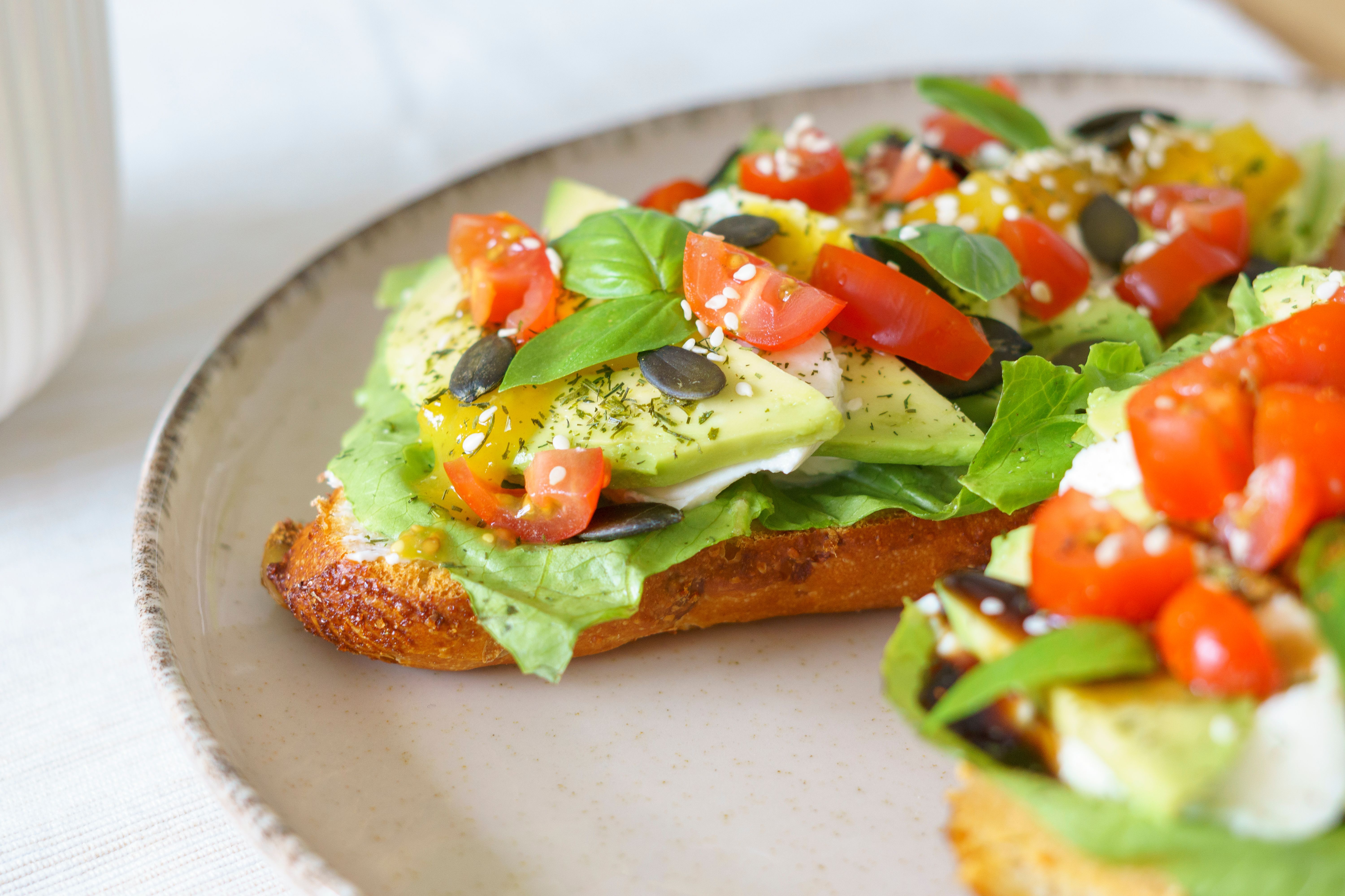 Sliced avocado on sourdough bread with seeds and sprouts