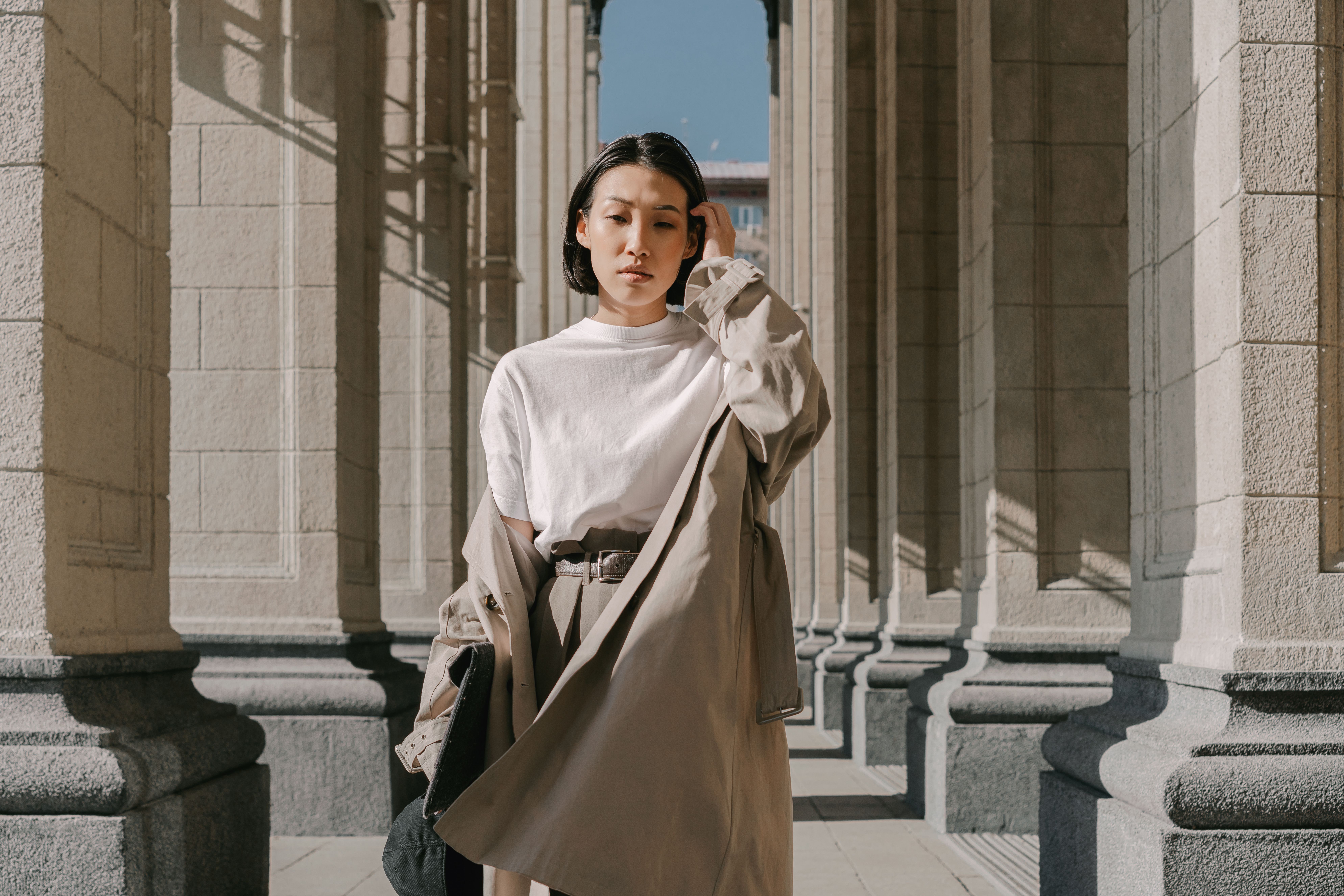 Classic vintage trench coat hanging against a neutral background