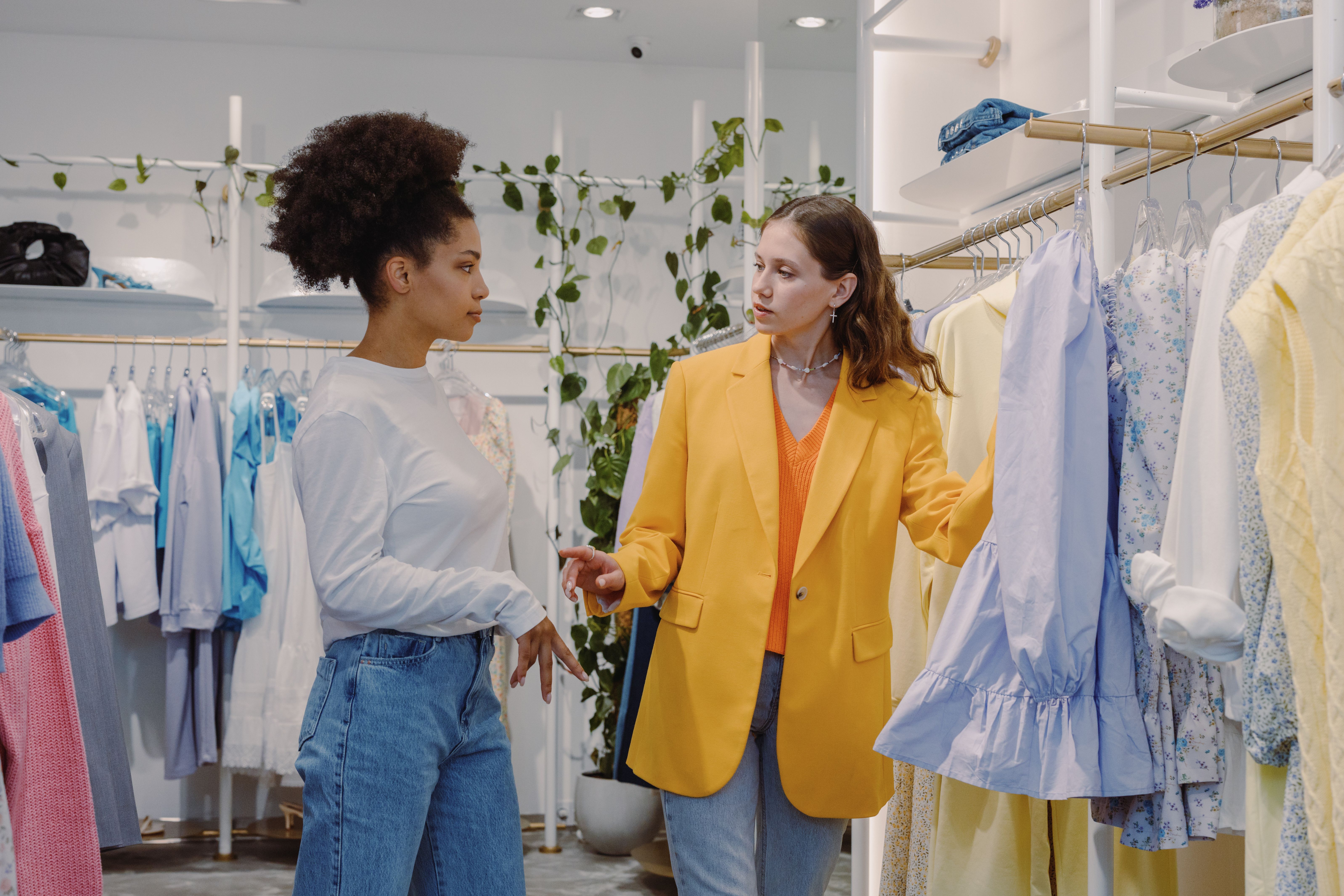 Customer smiling while browsing clothing racks in the shop