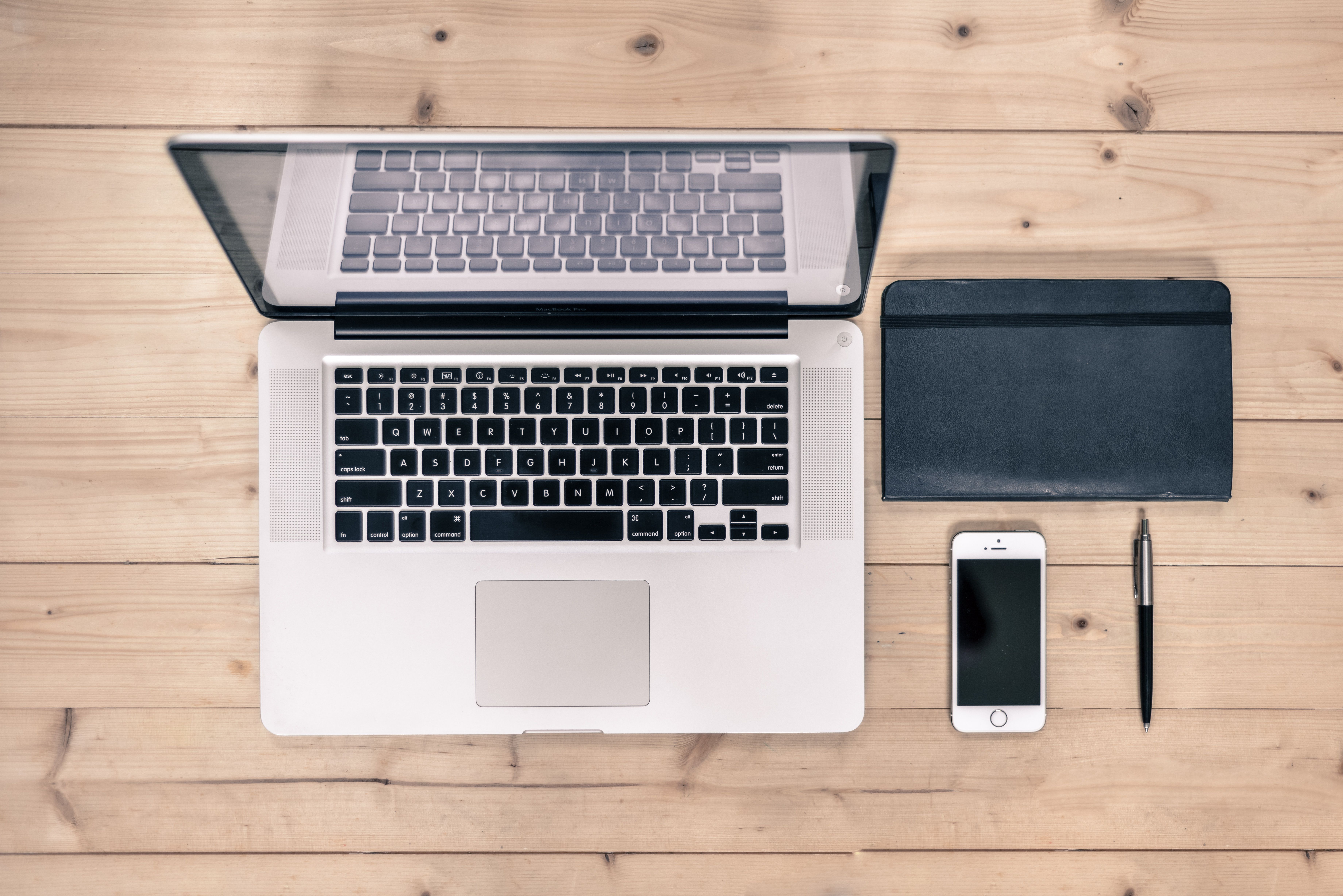 Modern desk setup with a laptop and a notebook