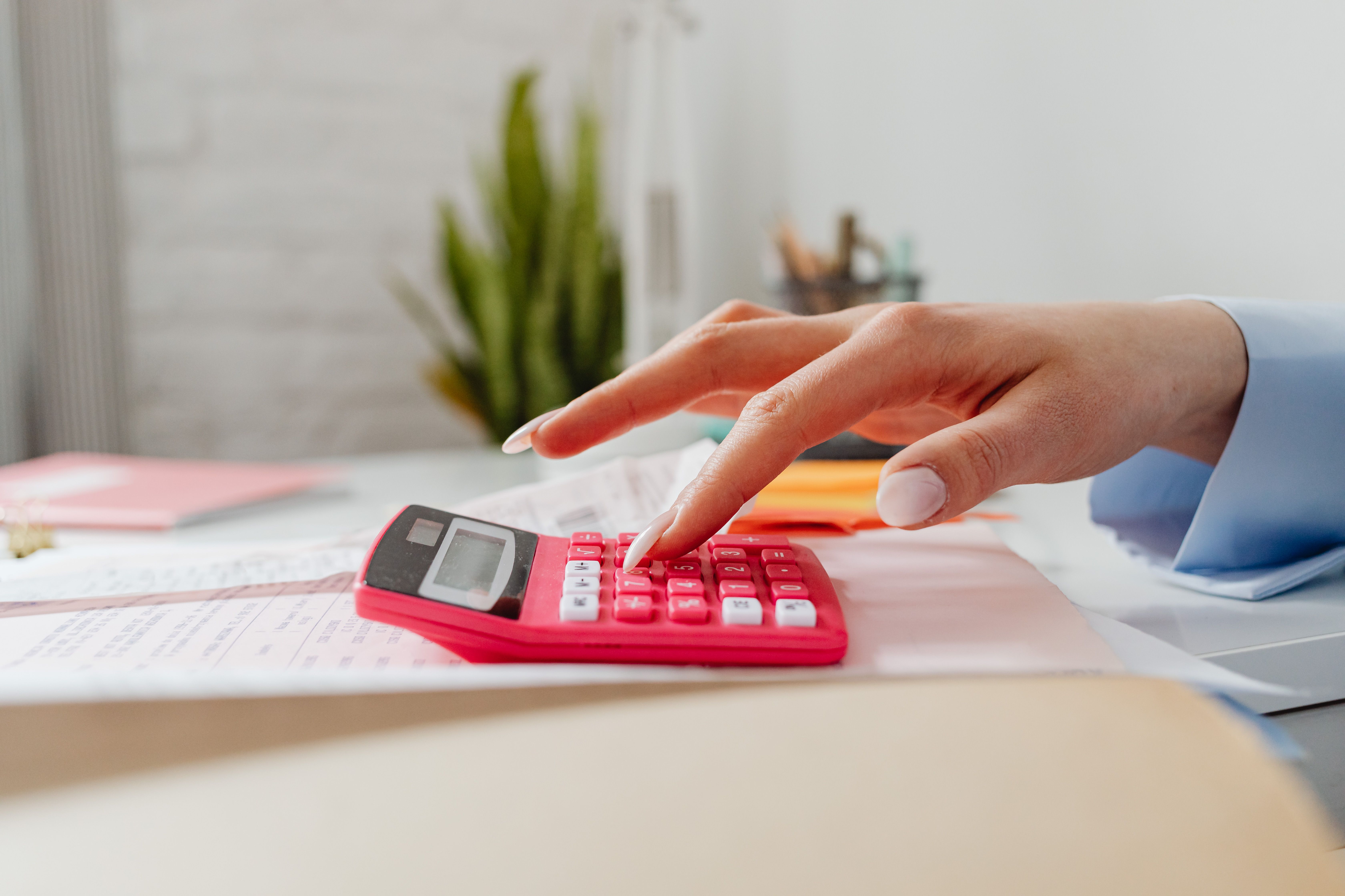 Close-up of a calculator and neatly stacked financial papers