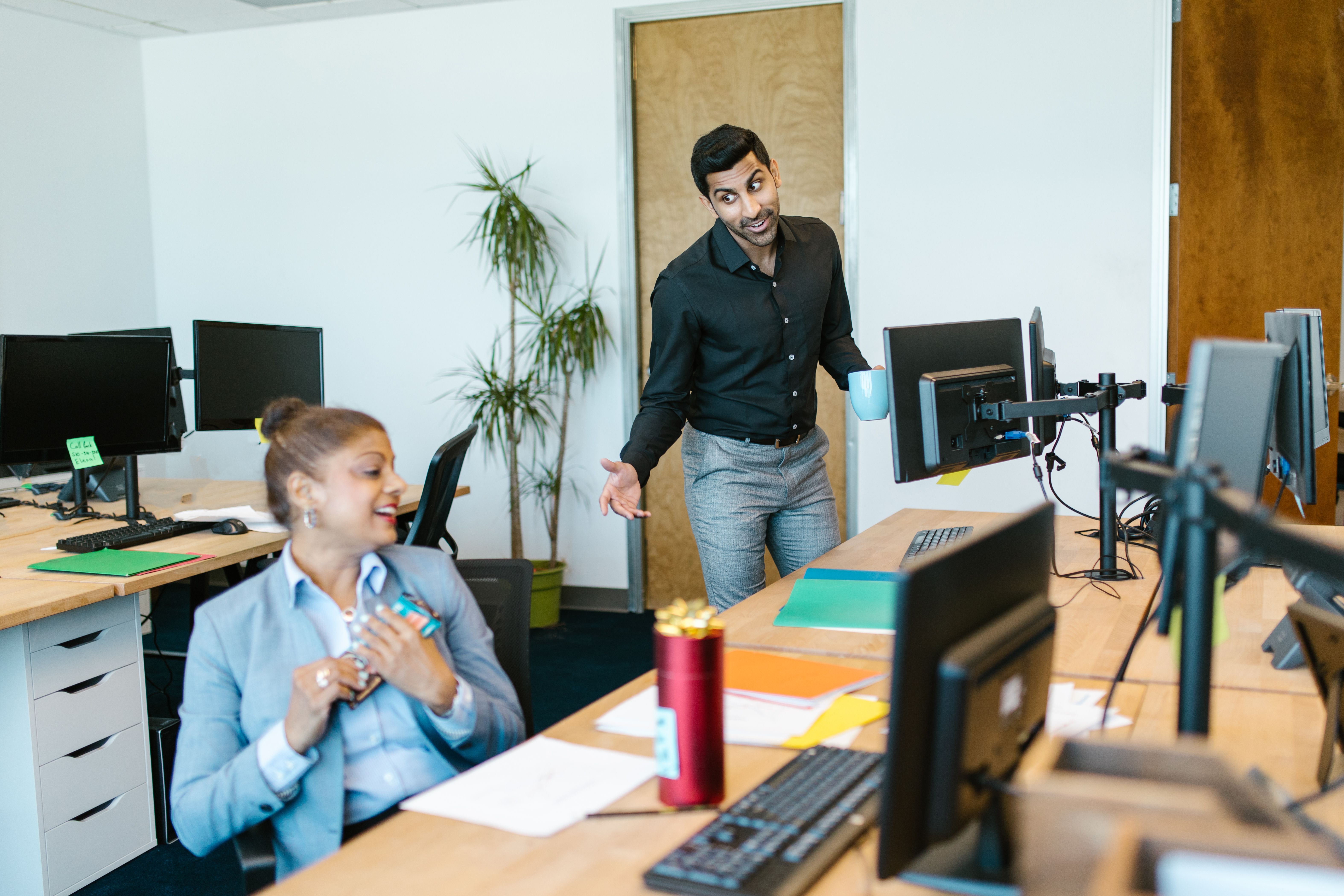Two colleagues talking in a friendly office environment
