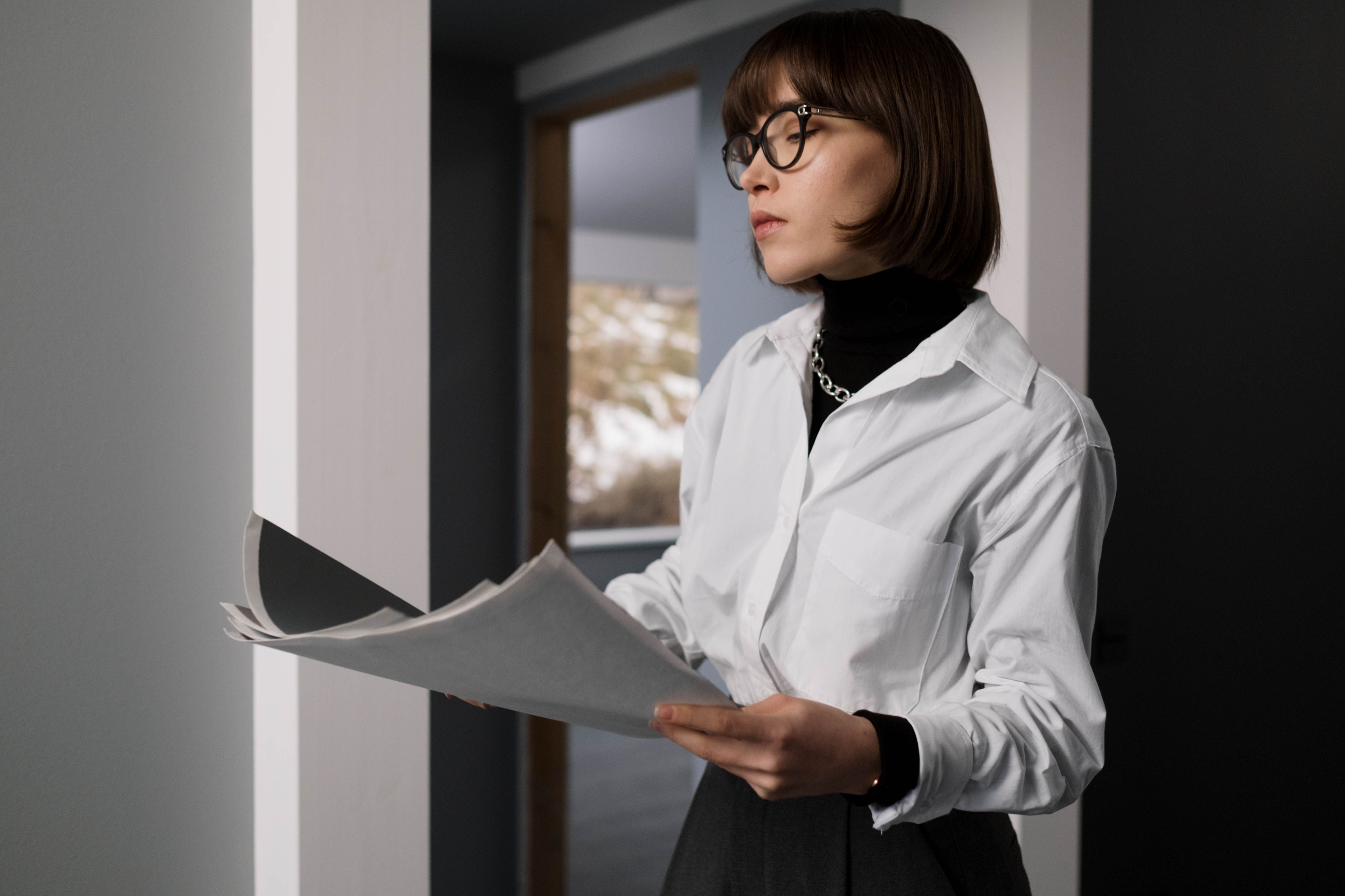 A pair of glasses resting on a stack of financial documents