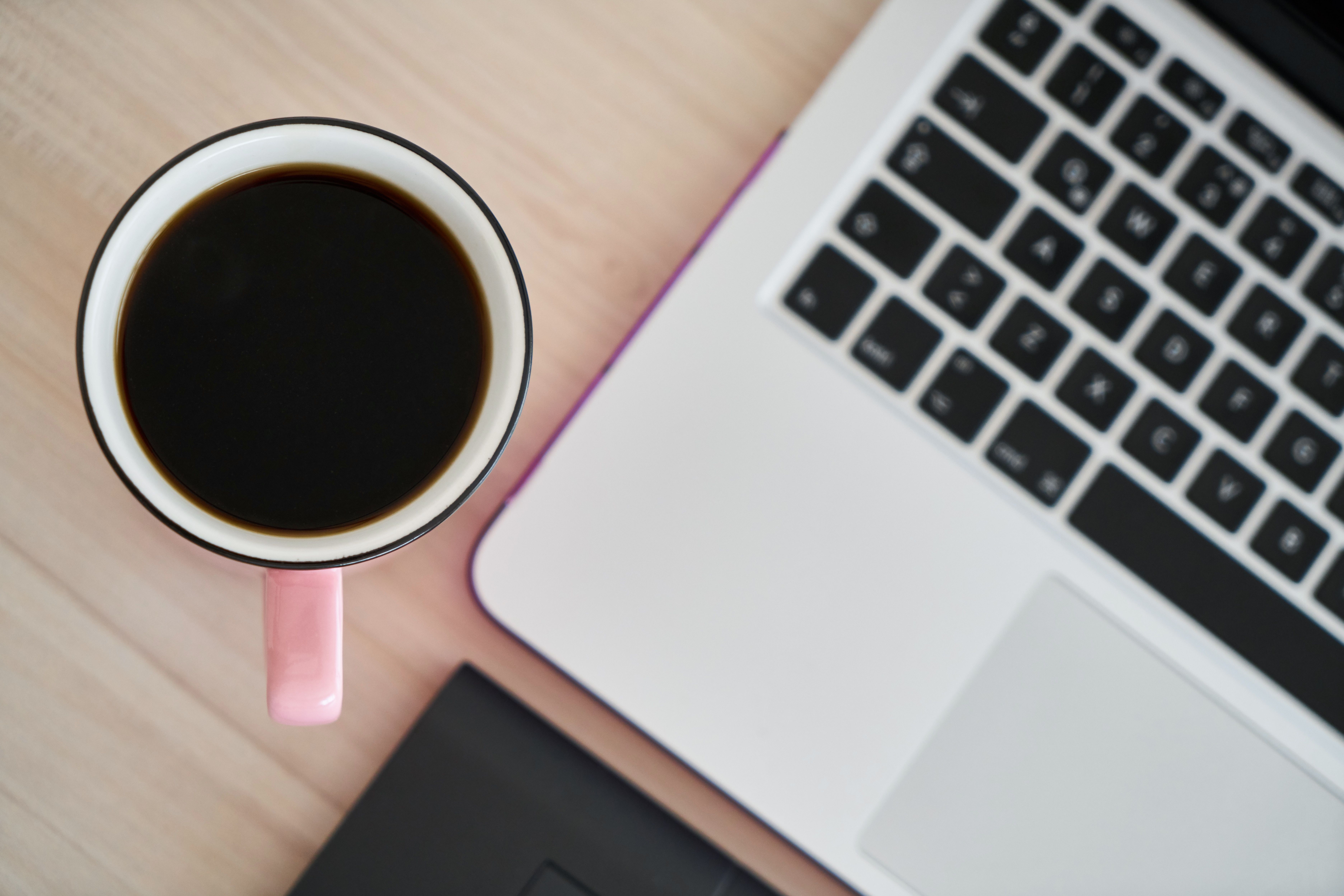 Aesthetic shot of a coffee cup next to a financial ledger