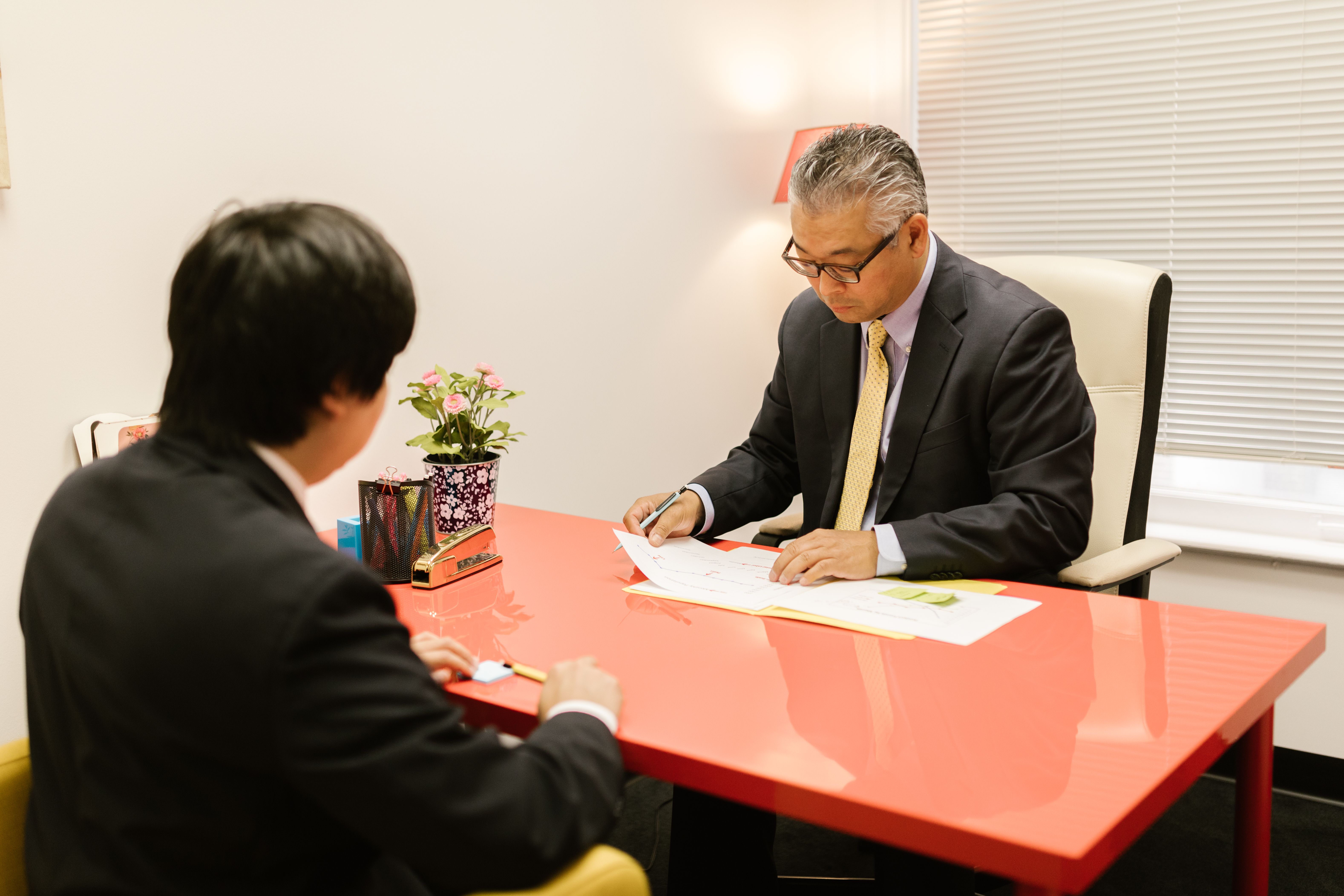 Two people talking across a desk in a professional consultation