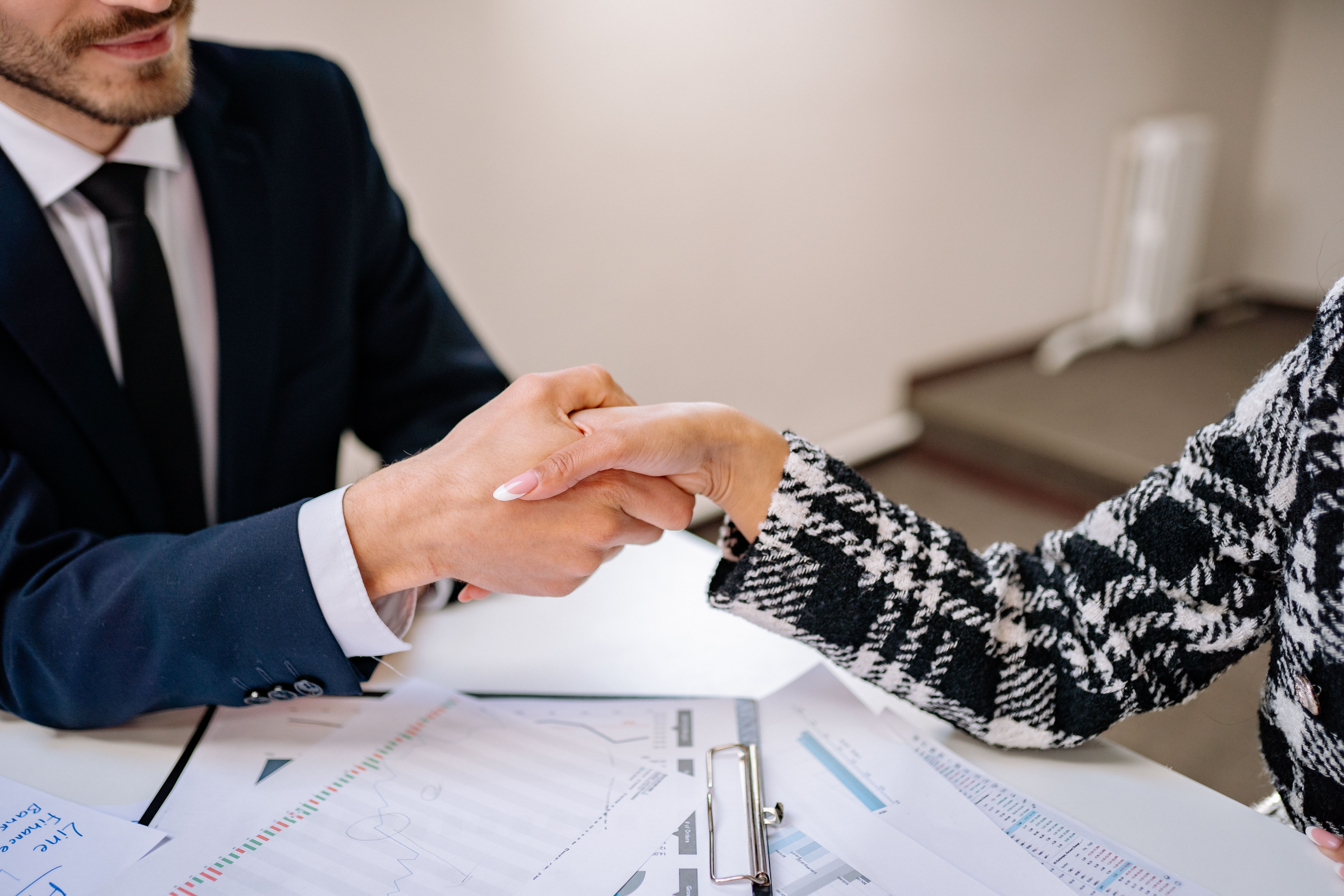 Two professionals shaking hands in a meeting room