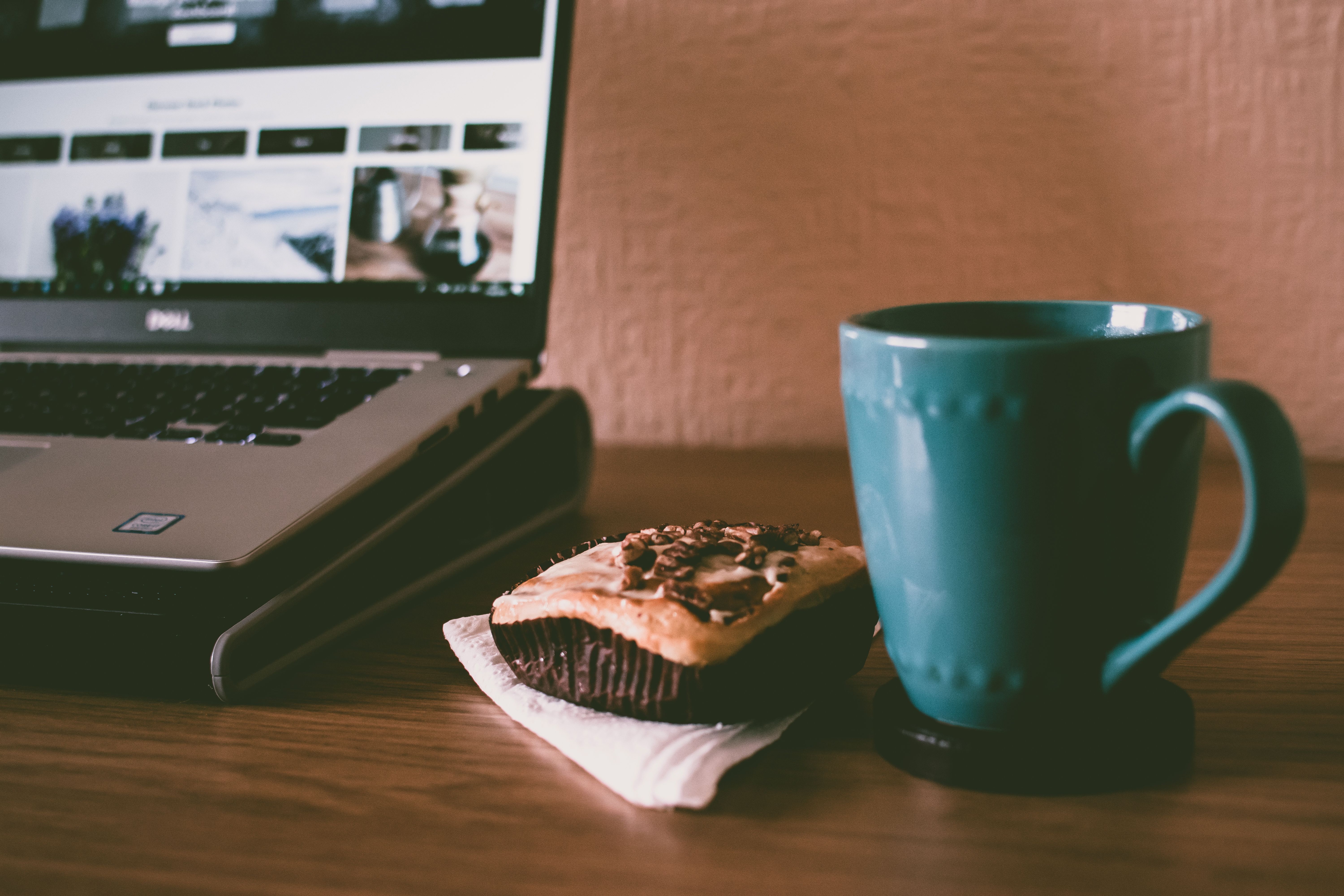 Coffee cup next to a laptop showing a spreadsheet