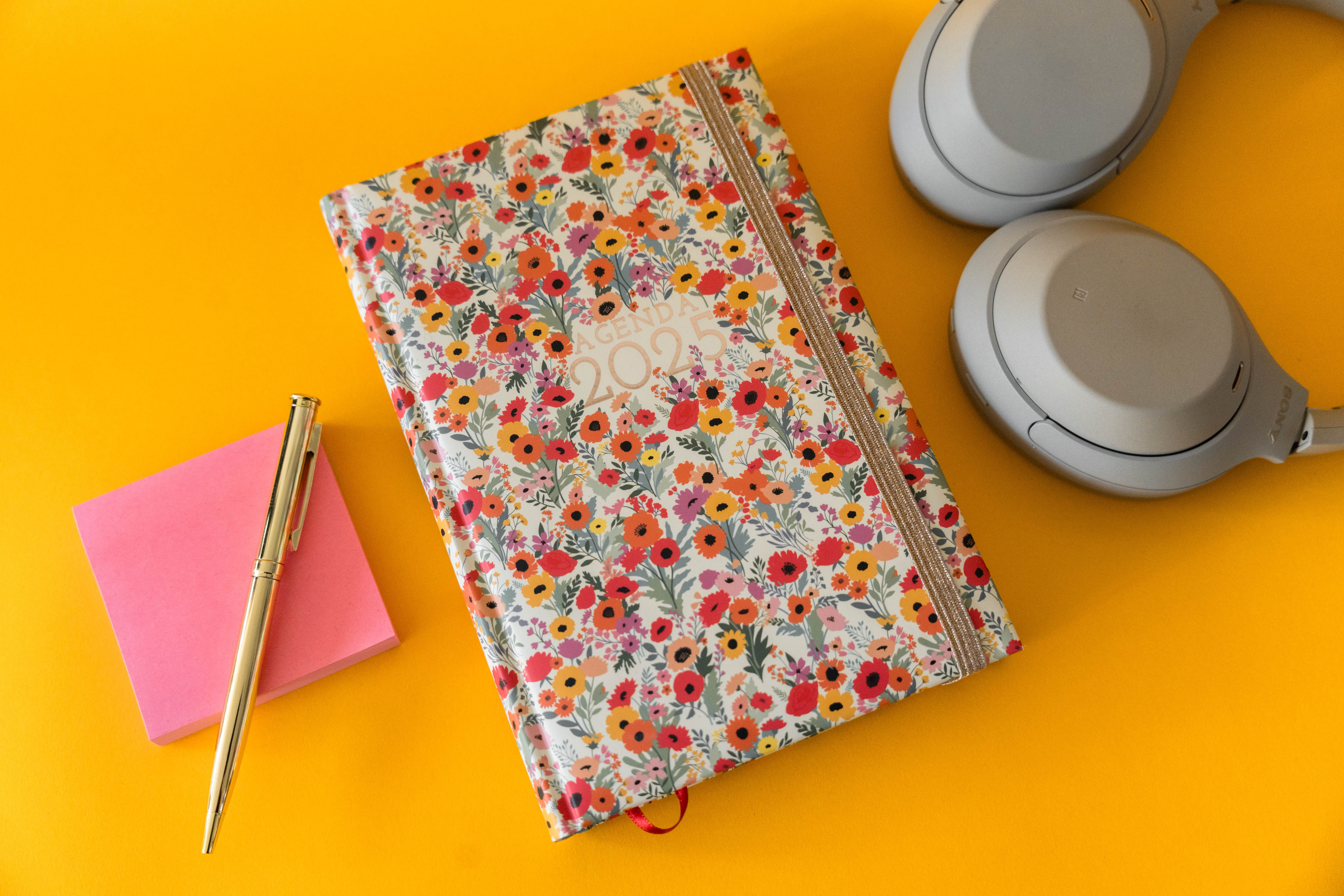 Person writing notes in a planner in a bright room