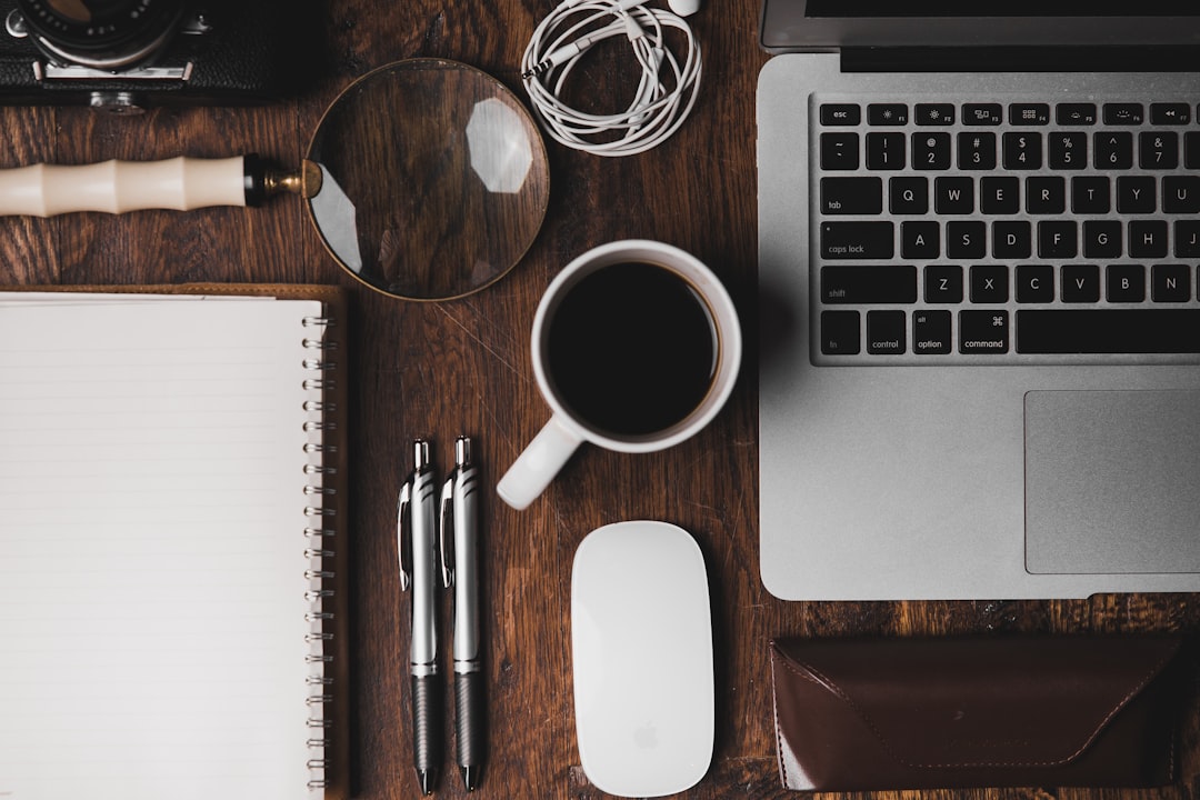 Clean workspace with a laptop, notebook, and a cup of coffee