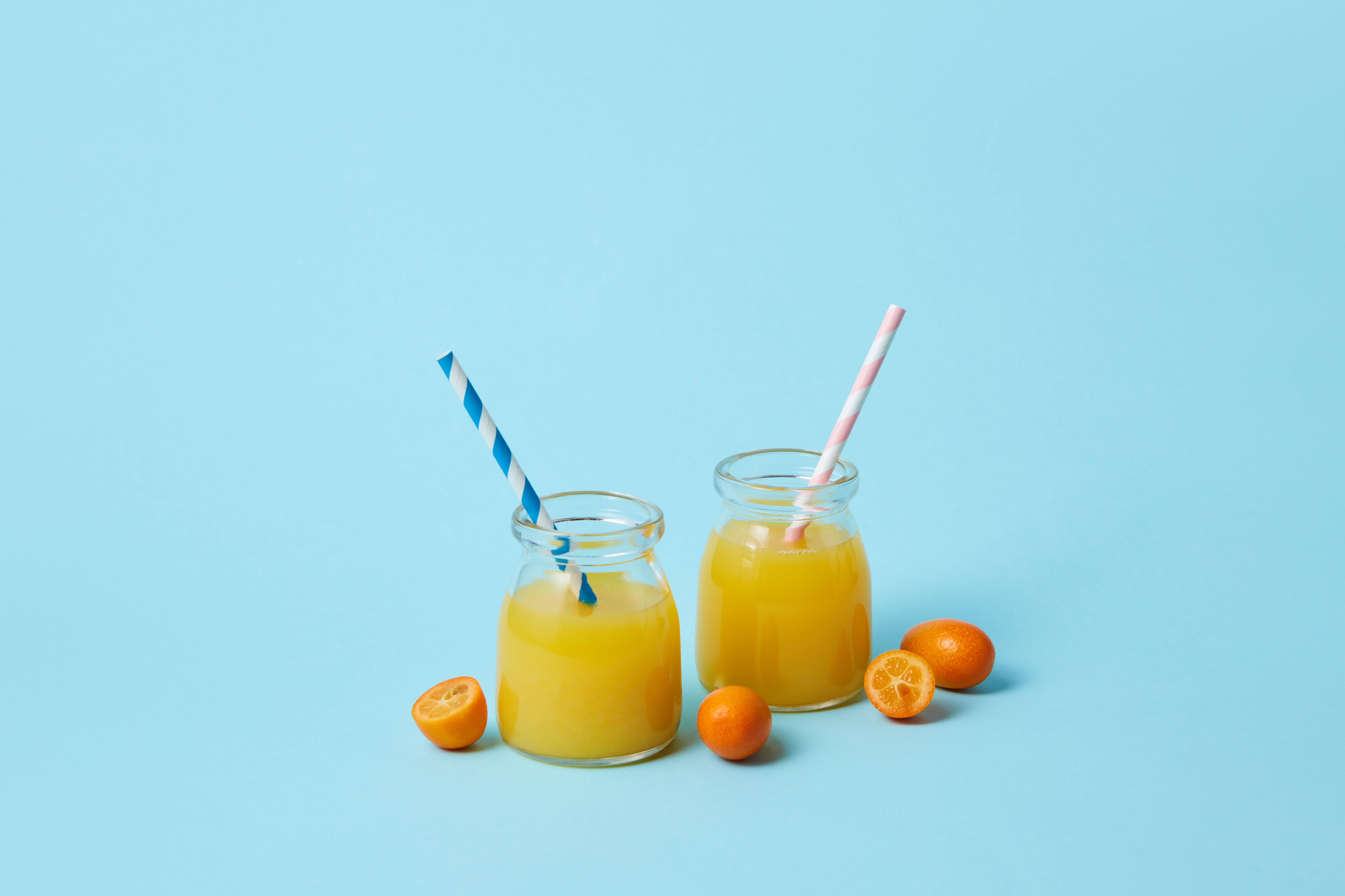 Glass of freshly squeezed orange juice with ice on a cafe table