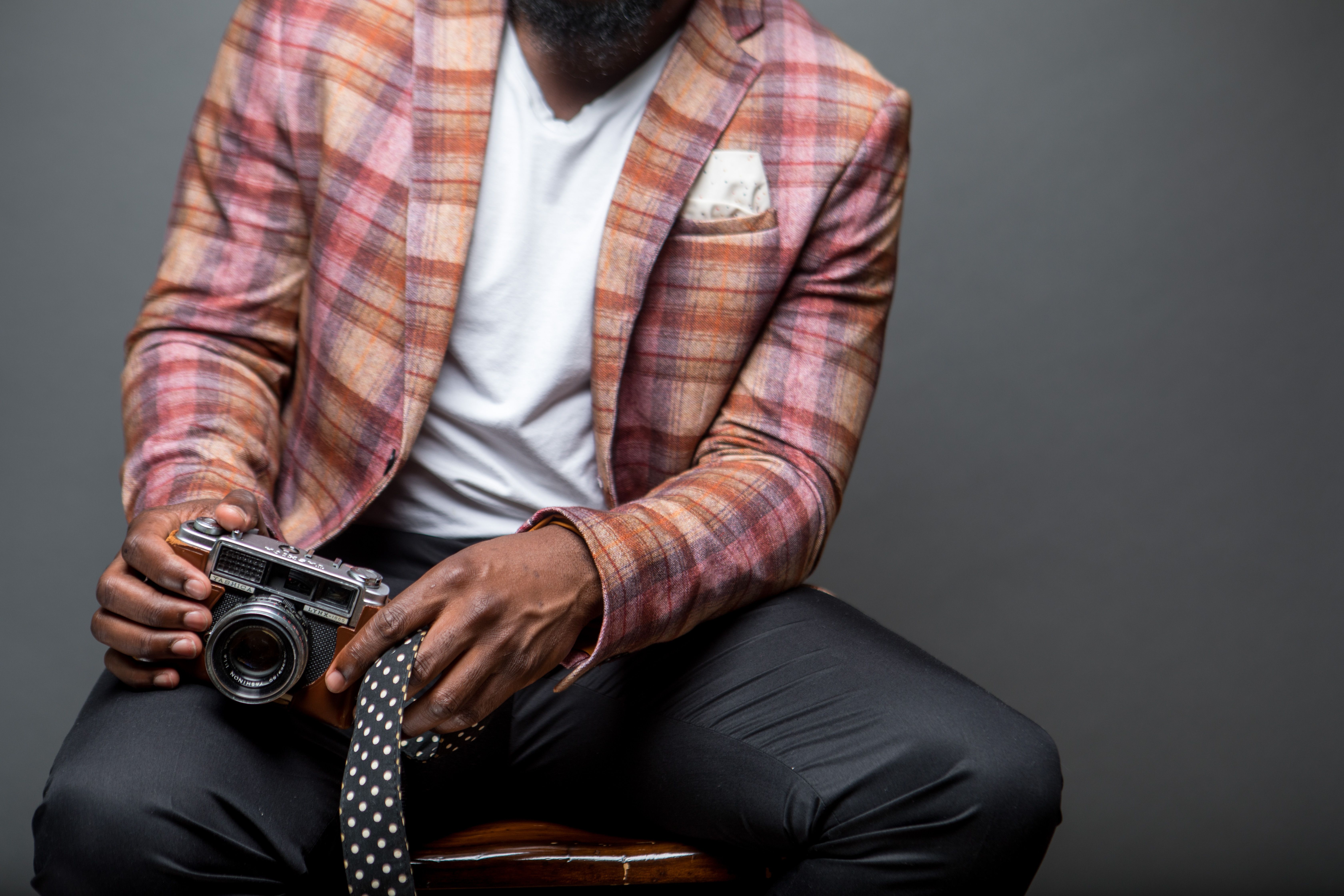 Hands inspecting the delicate fabric and stitching of a vintage designer blazer.