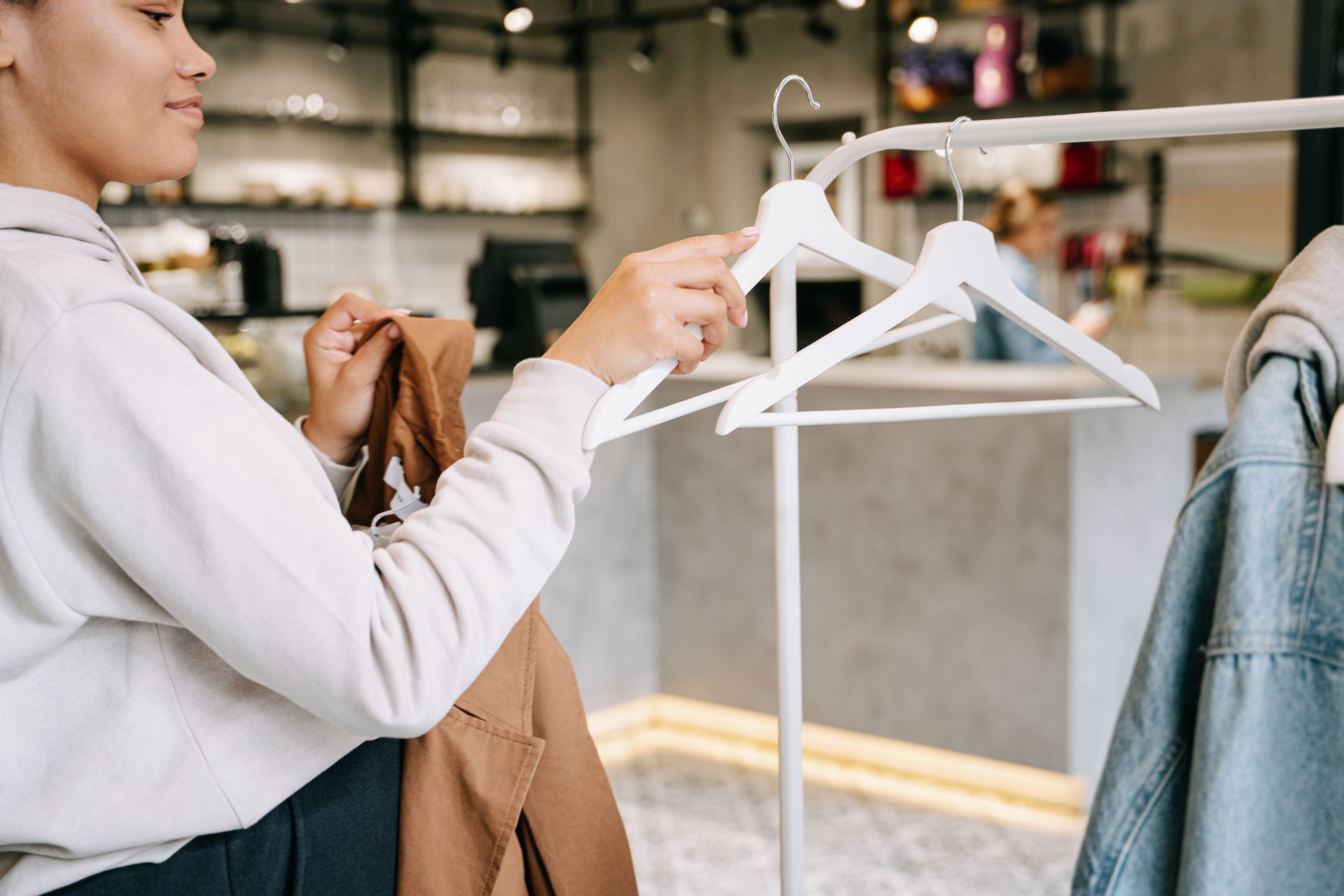 Person browsing through a rack of denim jackets